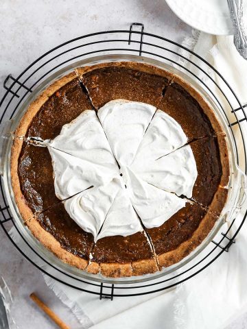 a sweet potato pie with coconut whipped cream on top