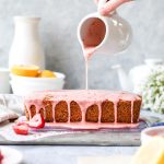 a loaf cake with strawberry glaze drizzling down the top