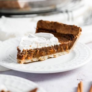 a slice of vegan sweet potato pie with coconut whipped cream