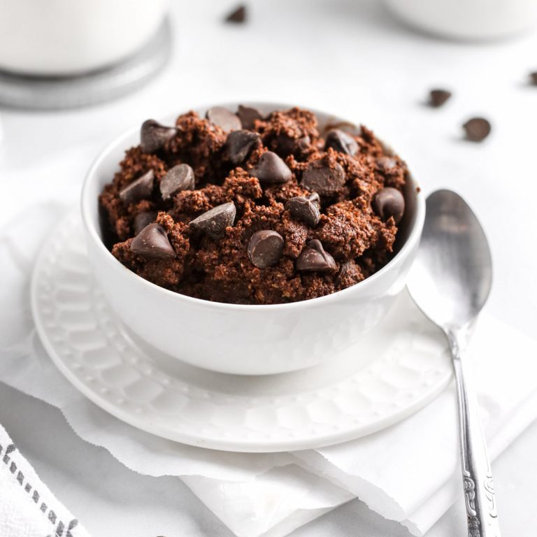 edible brownie batter in a white bowl with a spoon.