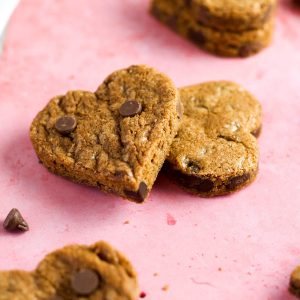 two heart shaped chocolate chip cookies leaning against each other