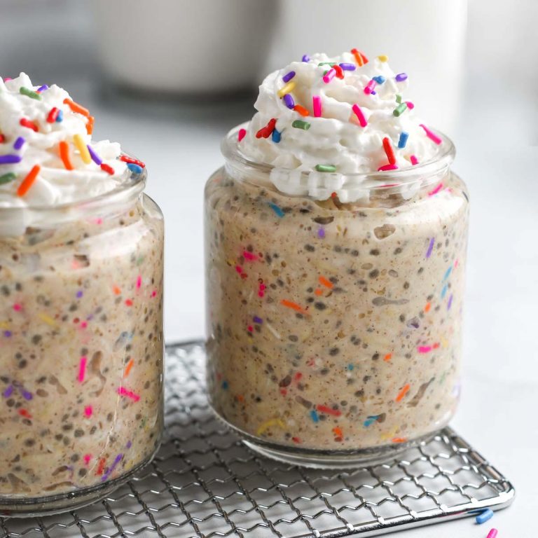 two jars of birthday cake overnight oats with coconut whipped cream and rainbow sprinkles.