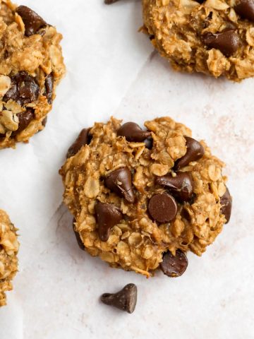 healthy banana oatmeal cookies on parchment paper with chocolate chips.