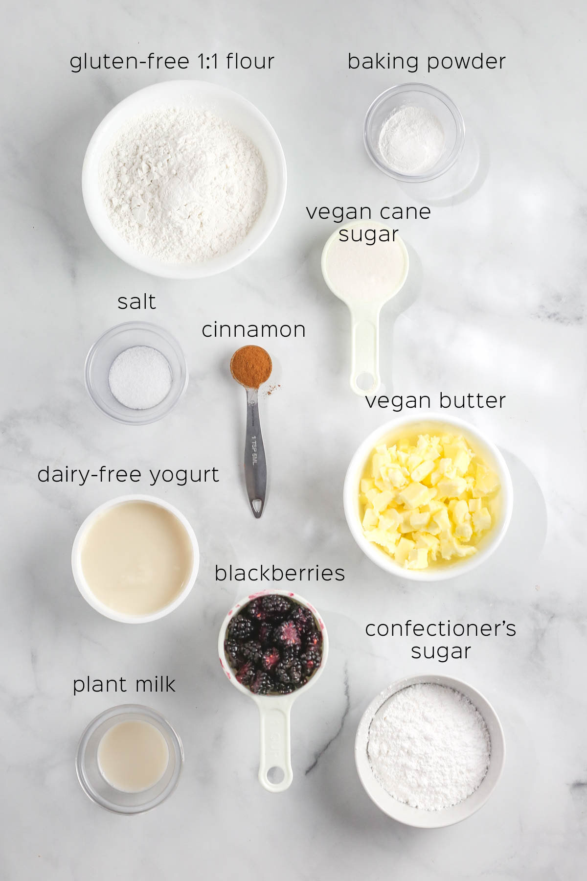 ingredients to make the scones, prepared in small dishes on a marble table.