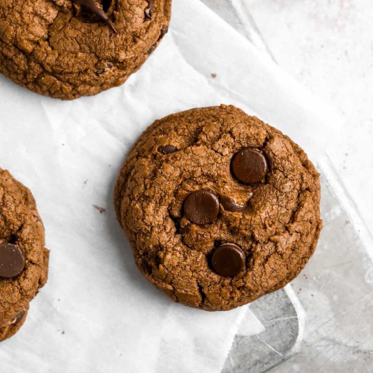 a gluten-free chocolate chip cookie on a tray with chocolate chips inside