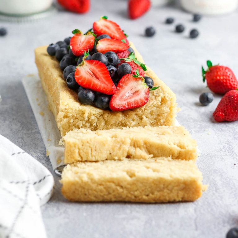 vegan pound cake with fresh strawberries and blueberries on top.
