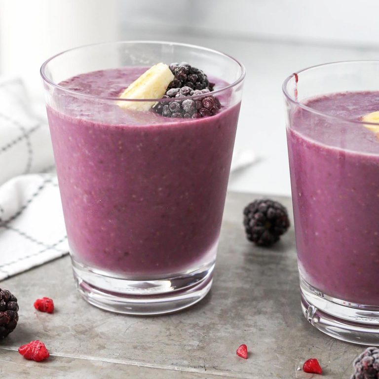two strawberry blackberry banana smoothies on a gray tray.