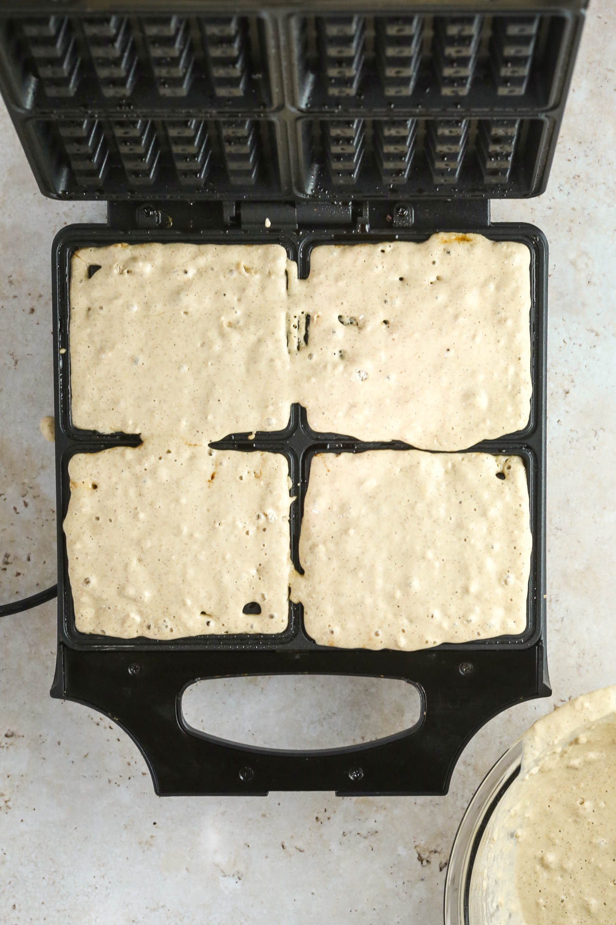 adding waffle batter to the waffle iron, shown from above.