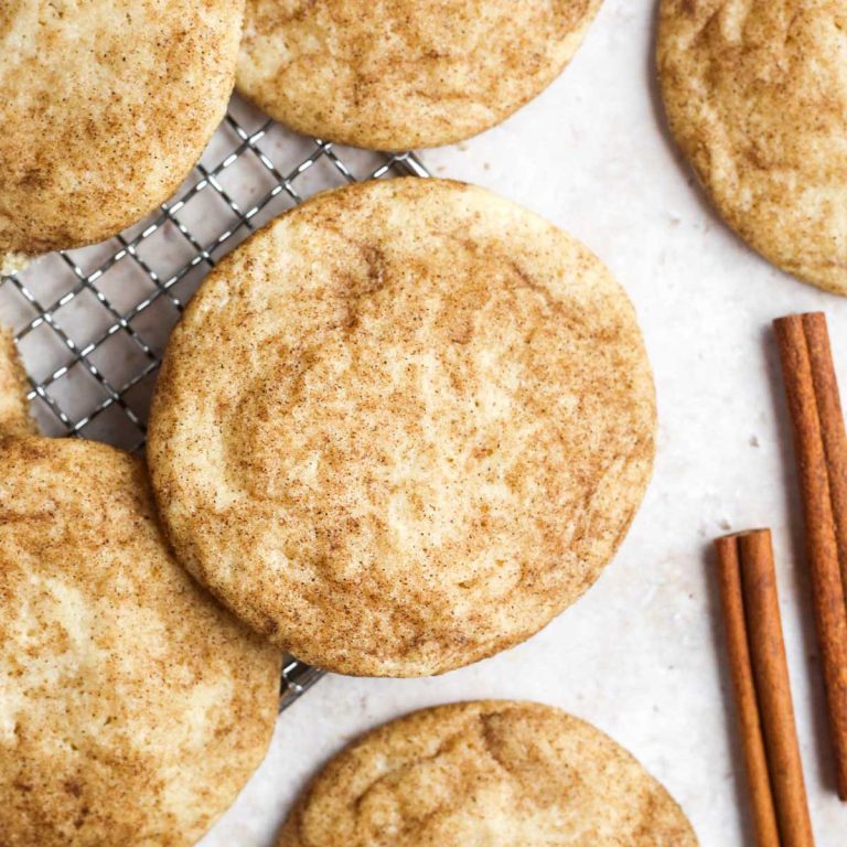 snickerdoodles on a wire tray with cinnamon sticks.