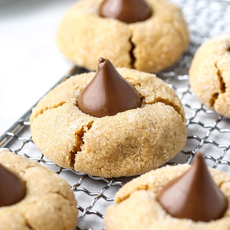 close up of peanut butter blossoms on a wire tray with glistening hershey kisses.