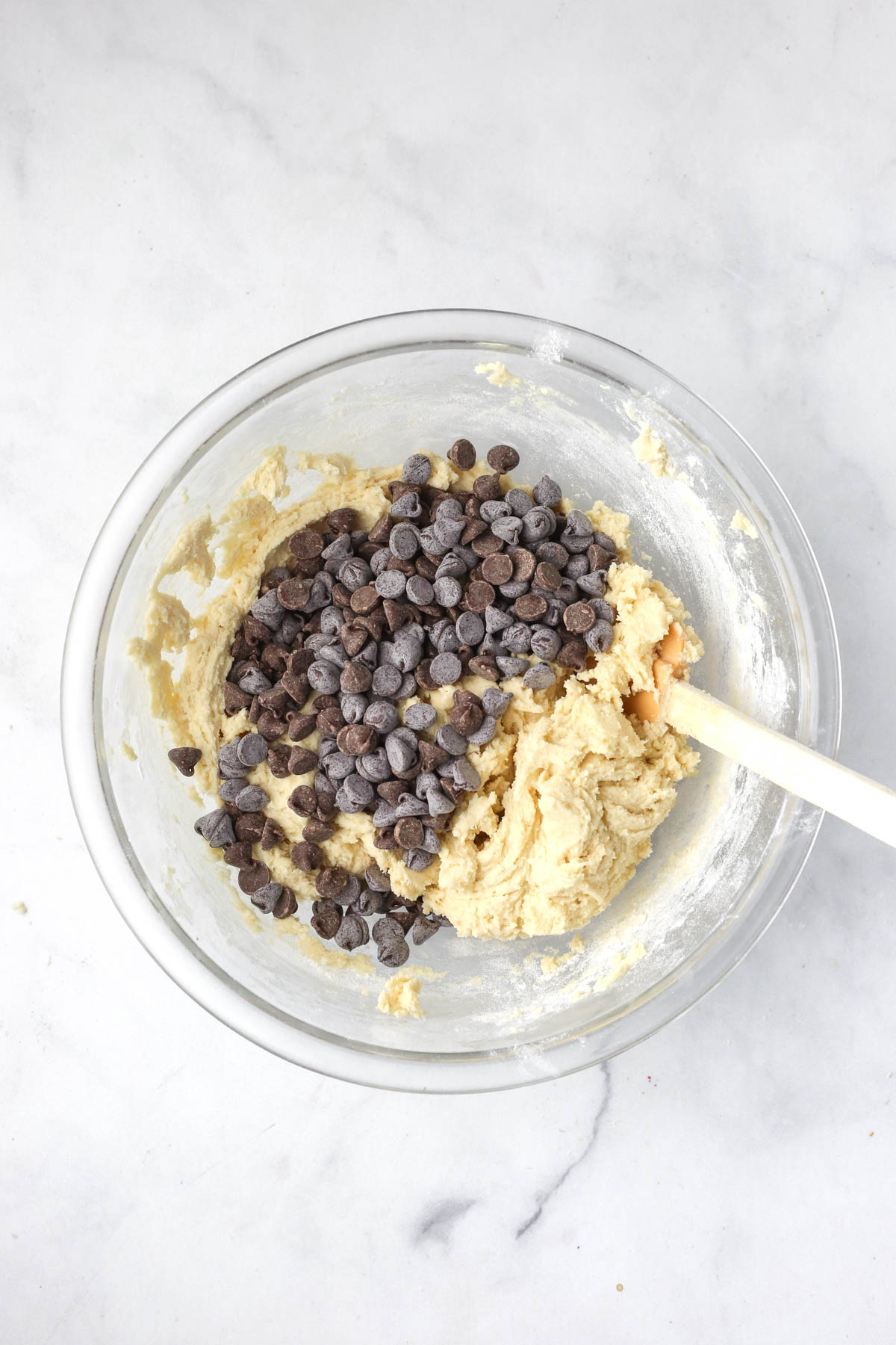 mixing the chocolate chips into the bowl of cookie dough.