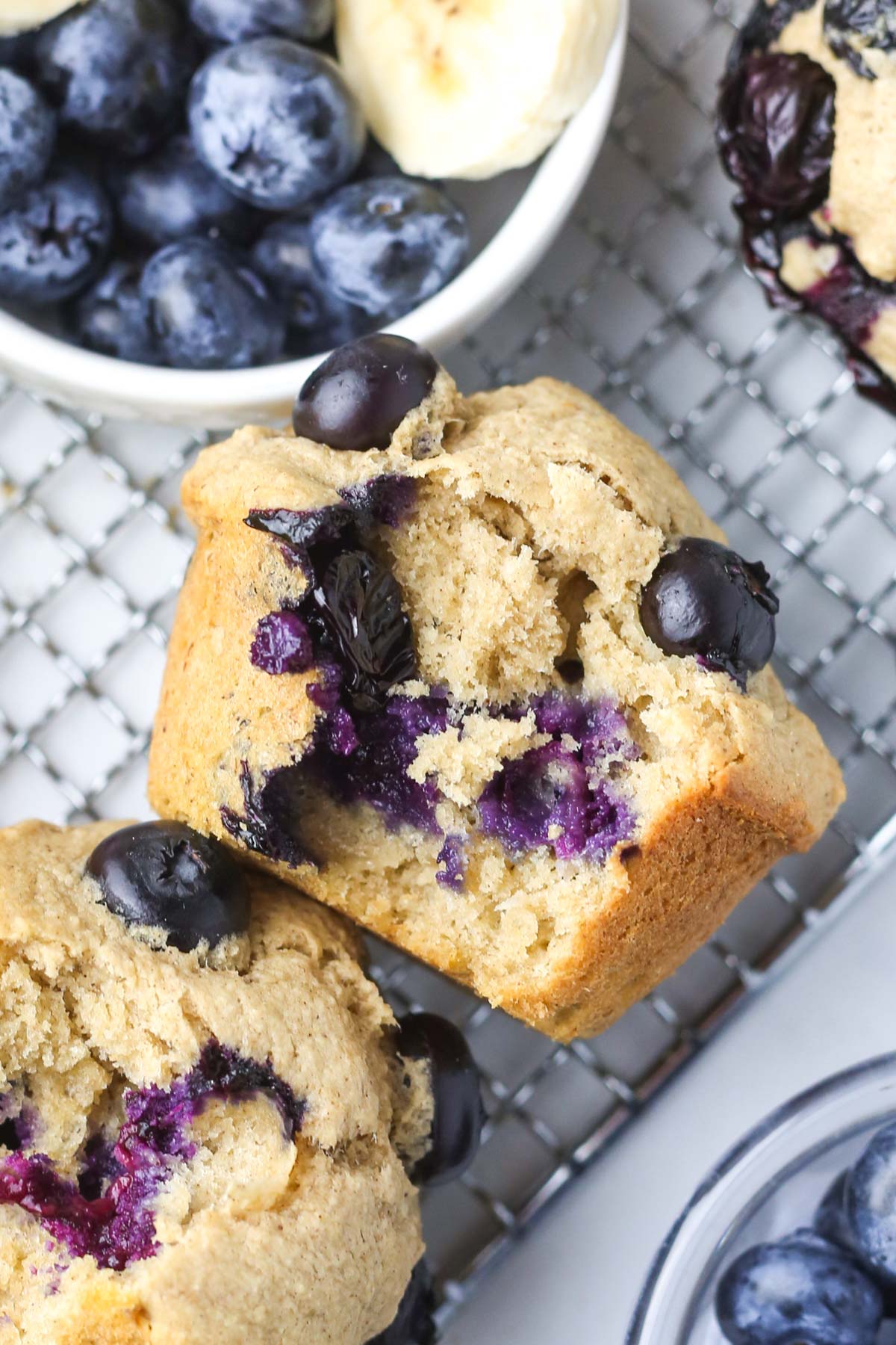 close up of the inside of a banana blueberry oat muffin, with purple blueberries inside.