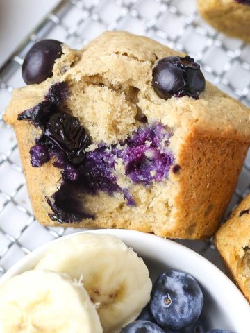 close-up of a healthy banana blueberry muffin with purple blueberries inside.