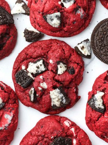 multiple oreo red velvet cookies shown from above with chunks of oreos baked into the tops of the cookies.