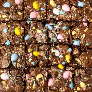 close up of cadbury mini egg brownies shown from above with colorful eggs baked into the top.