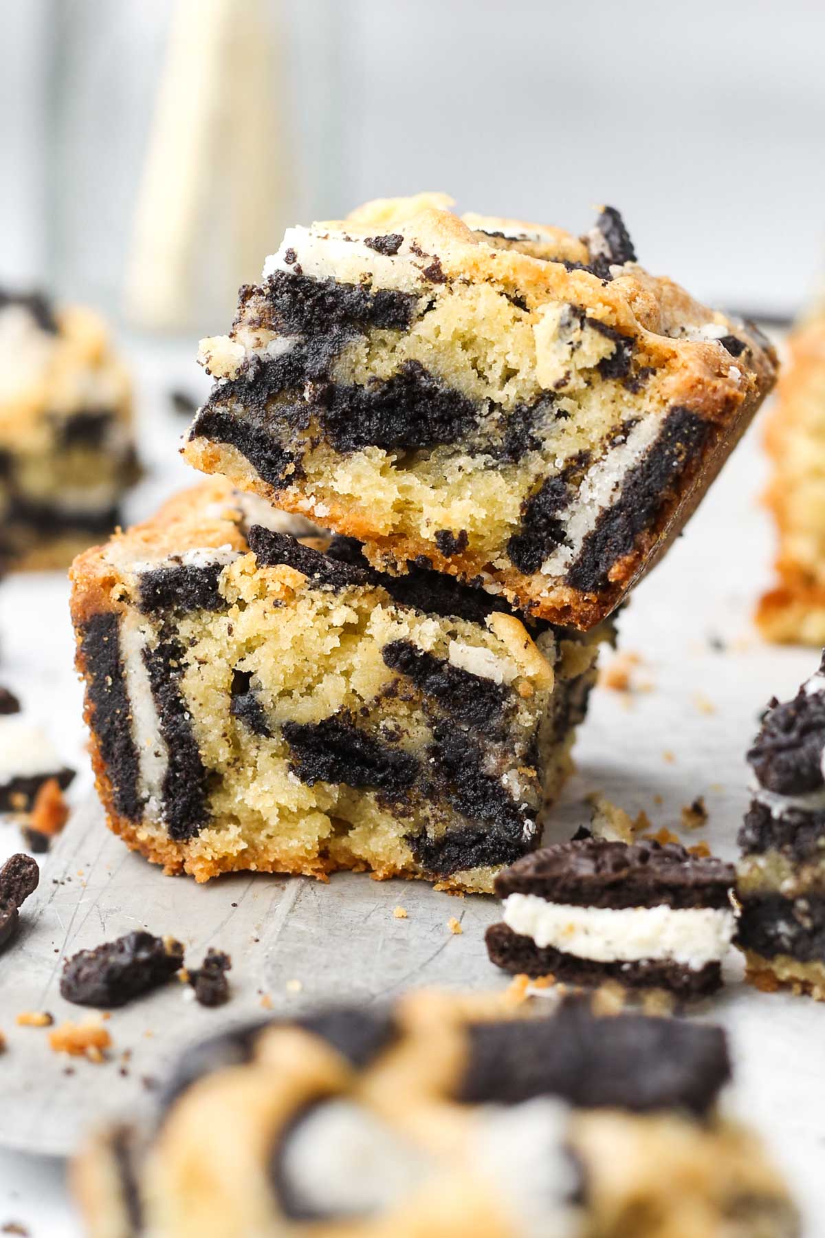 two oreo blondies stacked on top of each other and shown from the side, with oreo cookies baked inside.