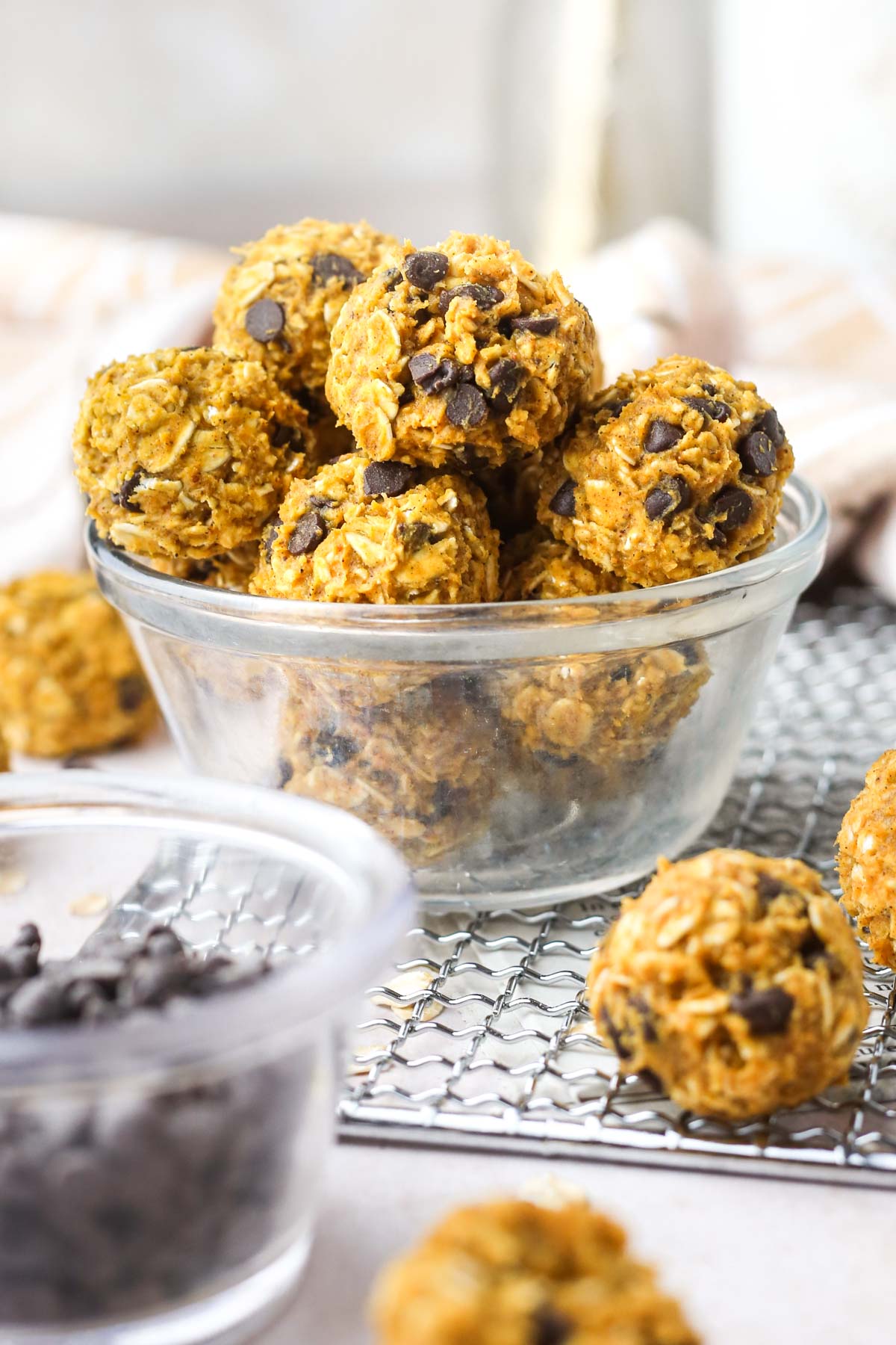 a small clear bowl full of healthy pumpkin protein balls with chocolate chips in each ball.