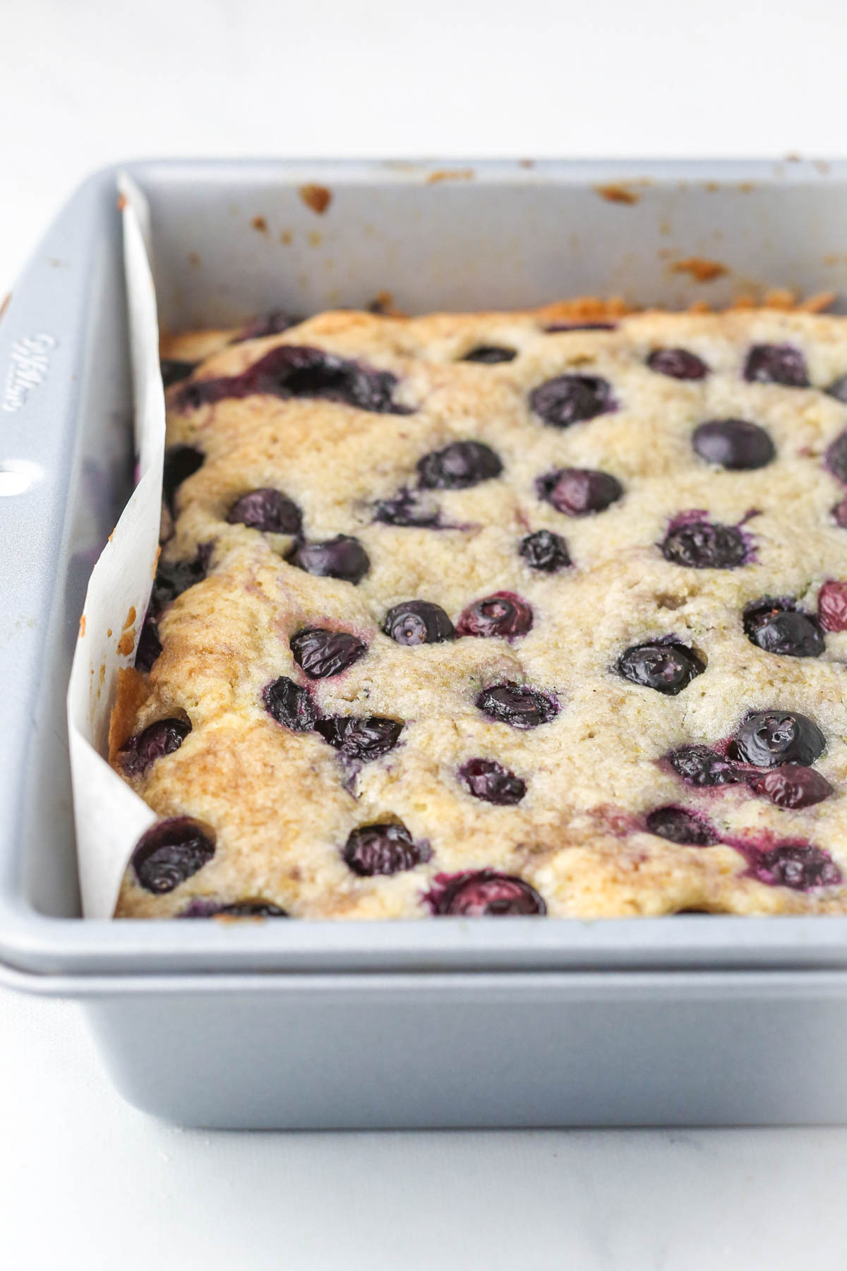 baked pan of lemon blueberry blondies, shown on an angle.