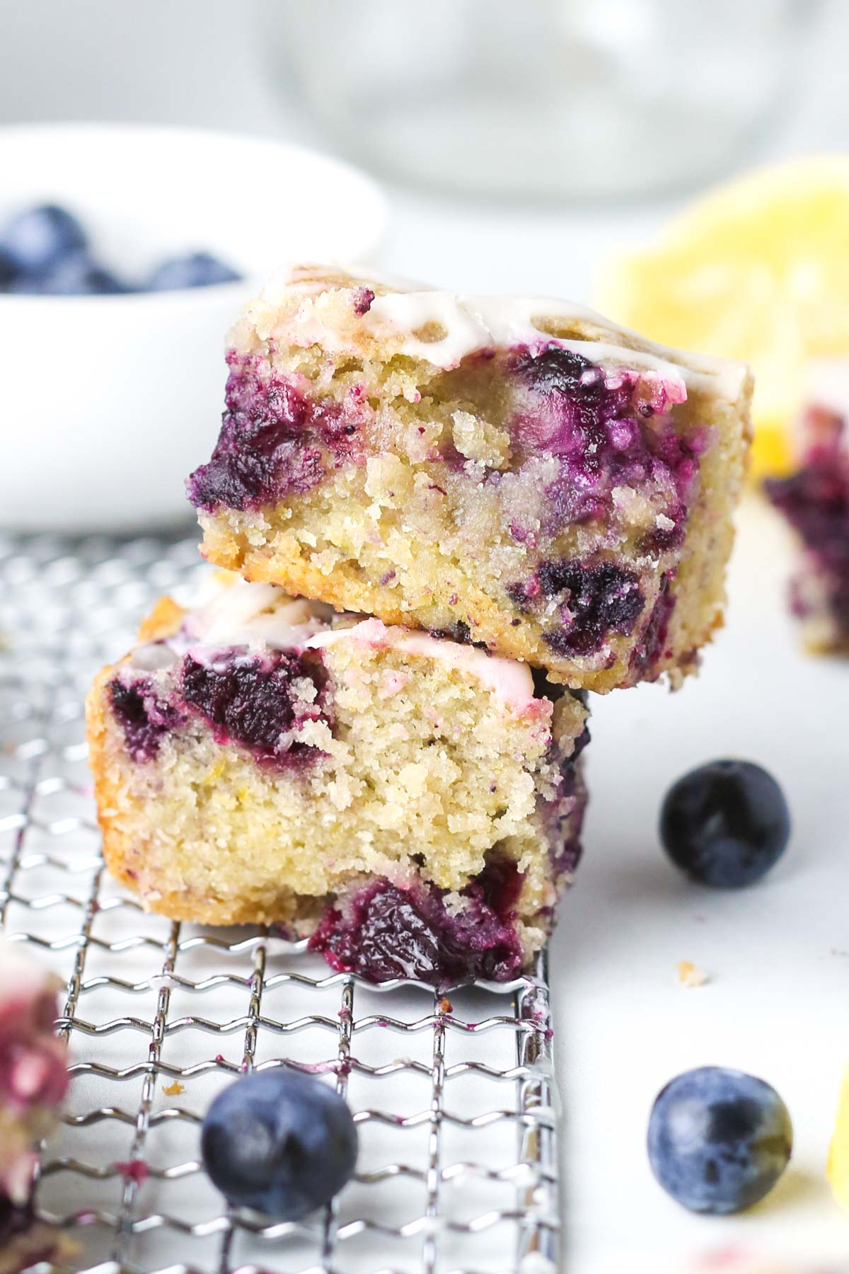 two lemon bars stacked on top of each other with blueberries inside.