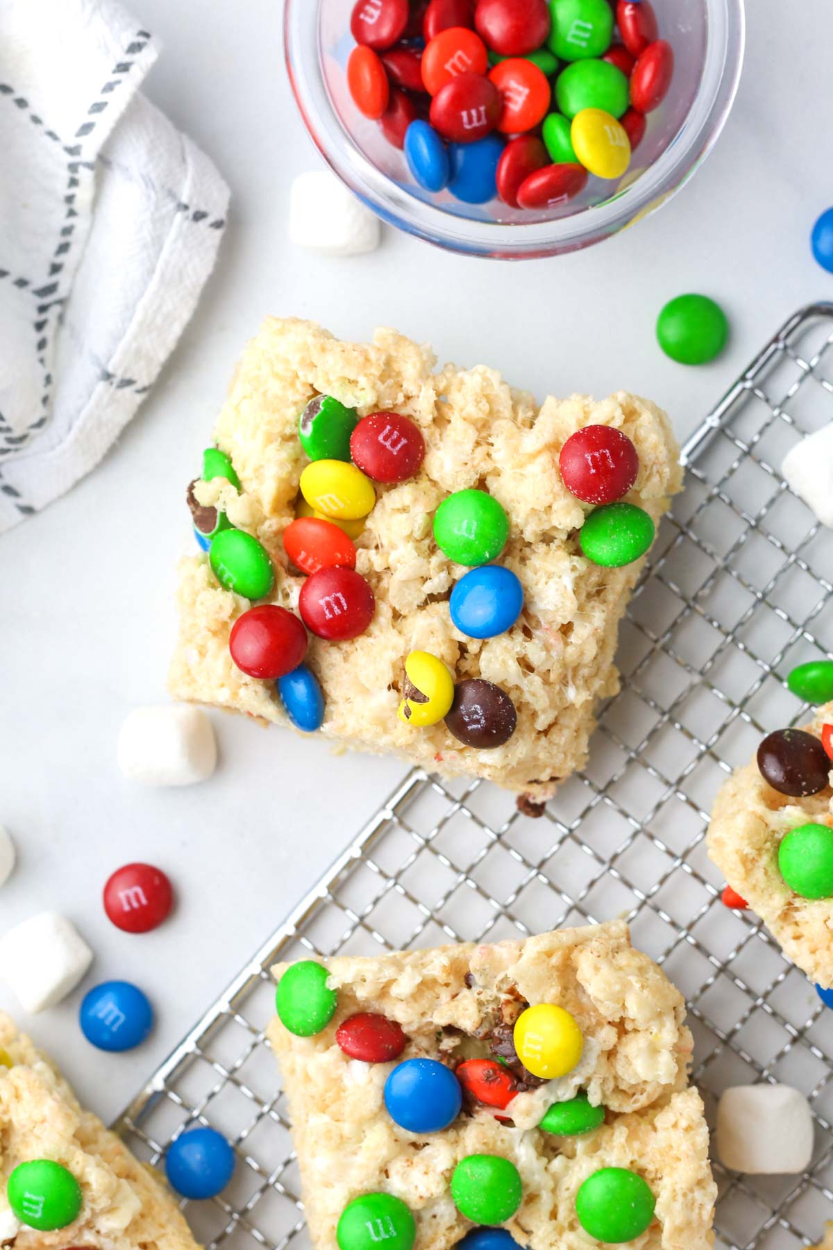 a few rice krispie treats shown from above with m&m chocolates around.