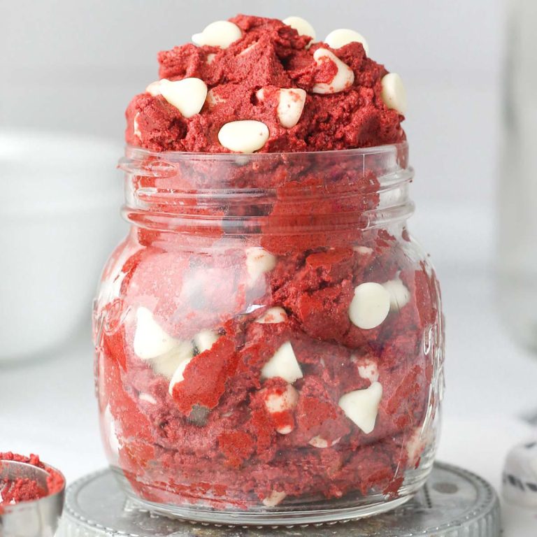 A jar filled with edible red velvet cookie dough and white chocolate chips.