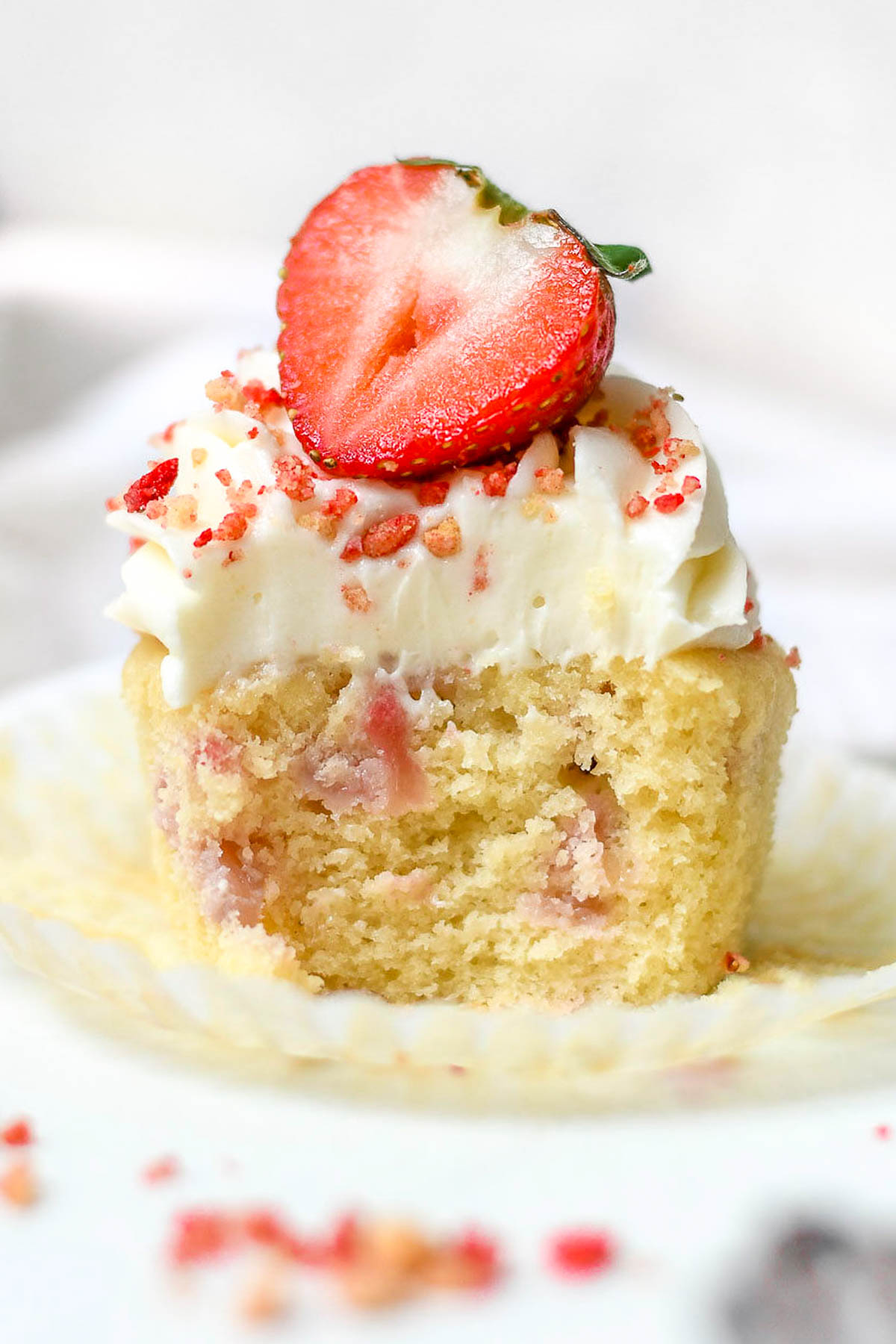 Inside of a strawberry crunch cupcake showing the fresh strawberries baked into the batter.