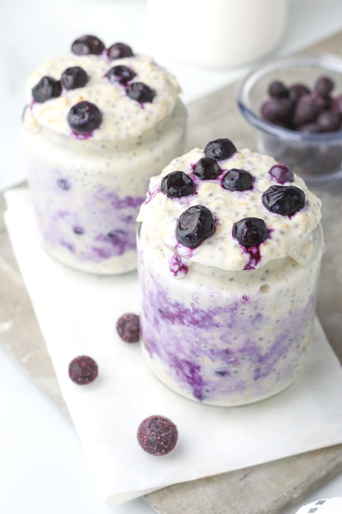 Two jars of cheesecake oats with blueberries on top.