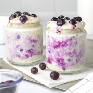 Two jars of healthy blueberry cheesecake overnight oats.