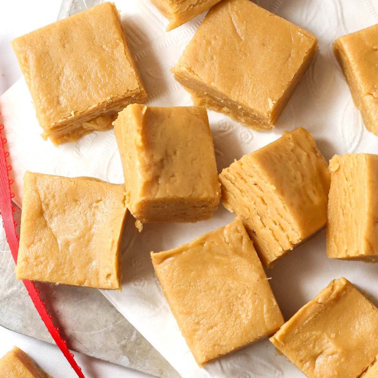 Multiple no bake peanut butter fudge squares shown from above on parchment paper.